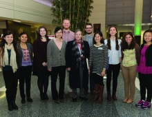 A group of students in a hospital atrium pose for a photo.